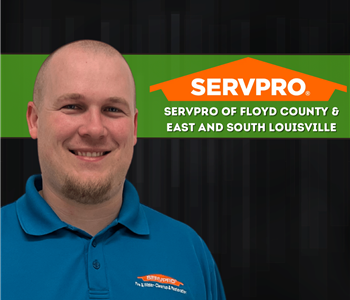 man in SERVPRO shirt looking at the camera with a black background 