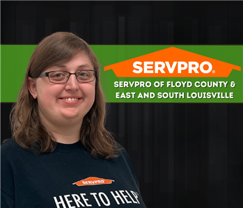 woman smiling at camera on a black background with a SERVPRO logo