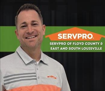 Man smiling at camera with black background and SERVPRO logo