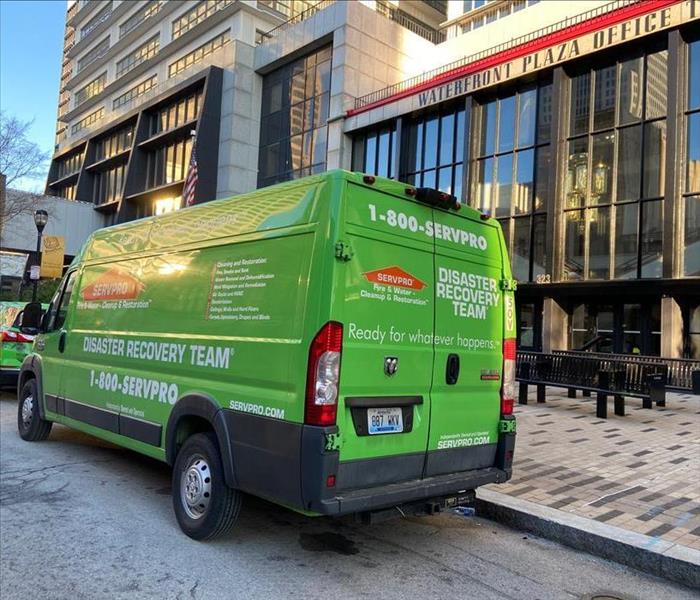 SERVPRO green van parked on the street in front of a downtown Louisville building following a fire and water damage.