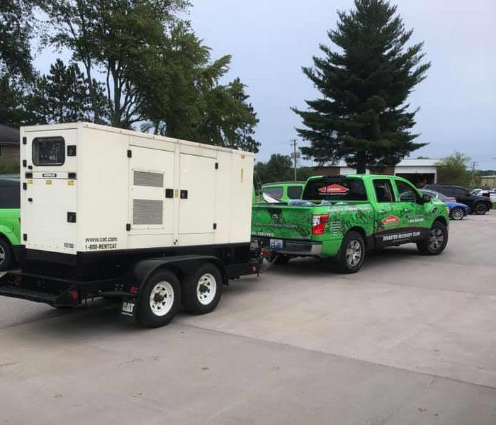 SERVPRO pick up truck pulling a trailer with a white piece of equipment